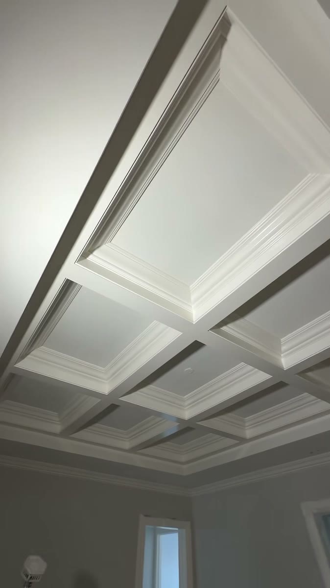 A freshly sprayed white coffered ceiling with deep beams.